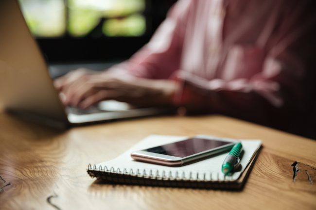 Man does not notice email message on phone on the table